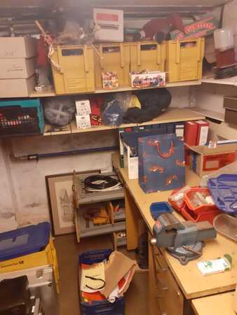 Werkstattkeller mit Regalen, Werkzeugen, gelben Kisten und verschiedenen Bastelmaterialien.